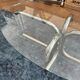Oval glass coffee table with chrome legs, vintage 70s design.