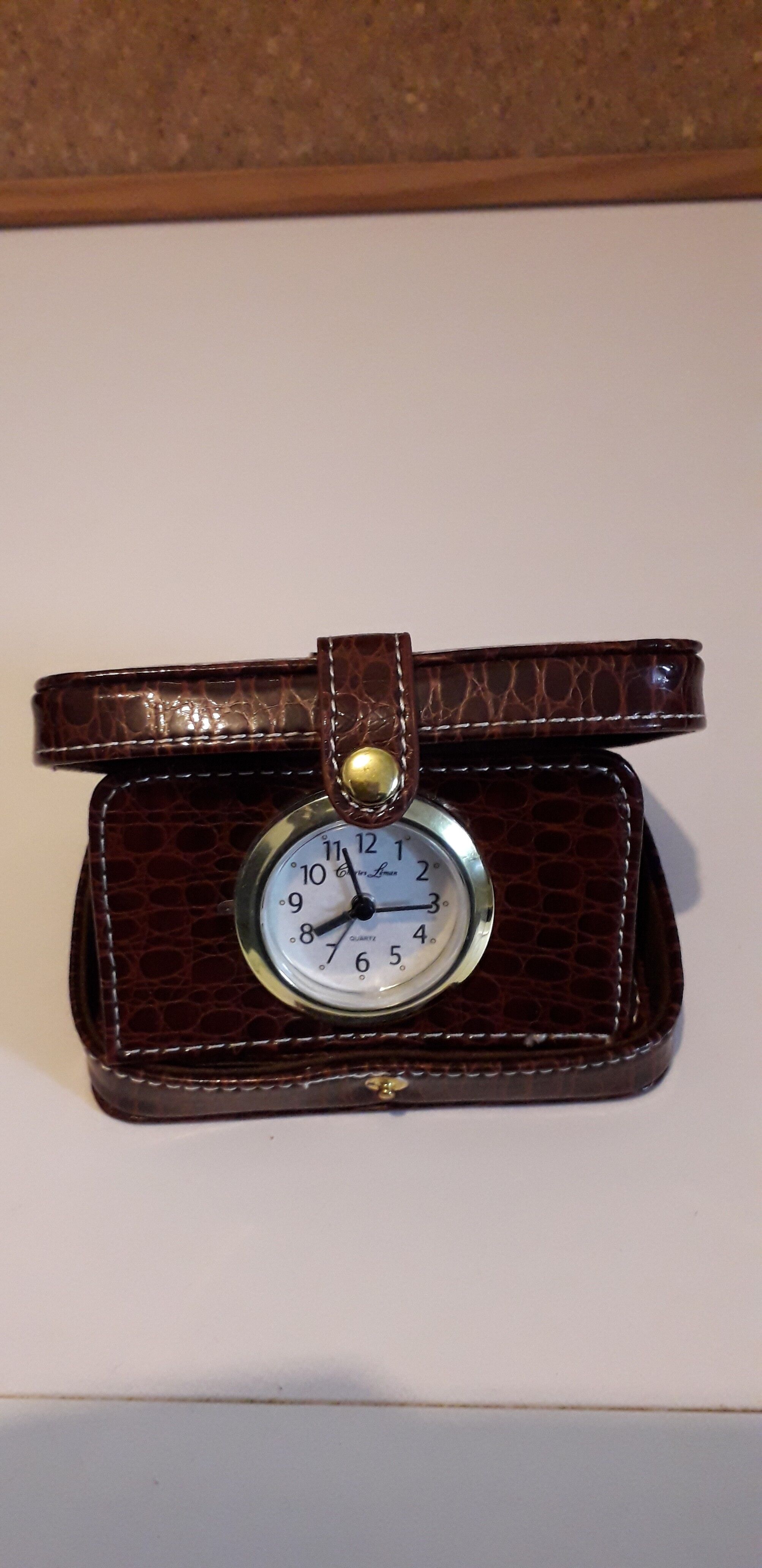 Small travel alarm clock in its case with jewelry compartments