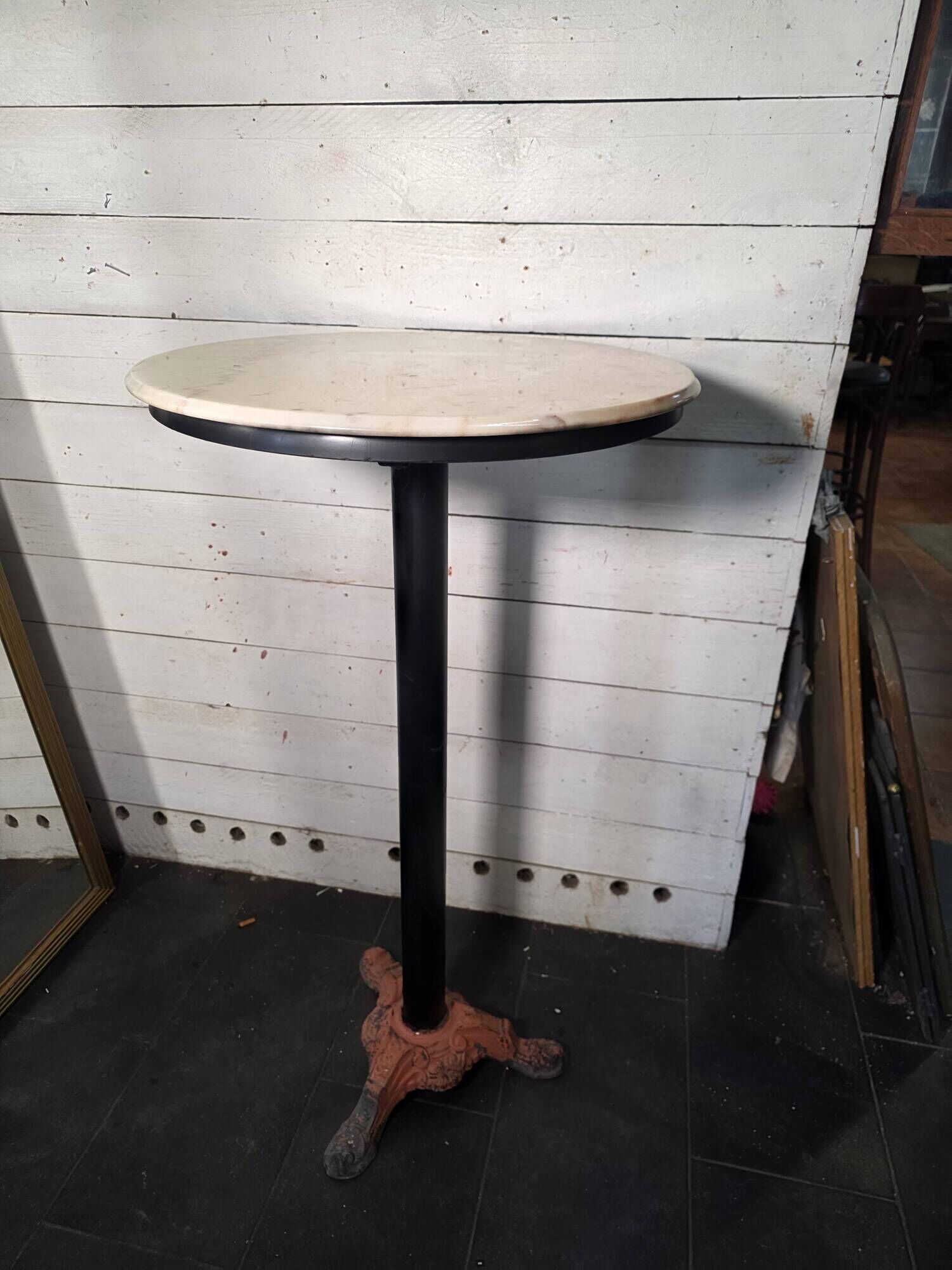 Bistro standing table with marble top and cast iron base.