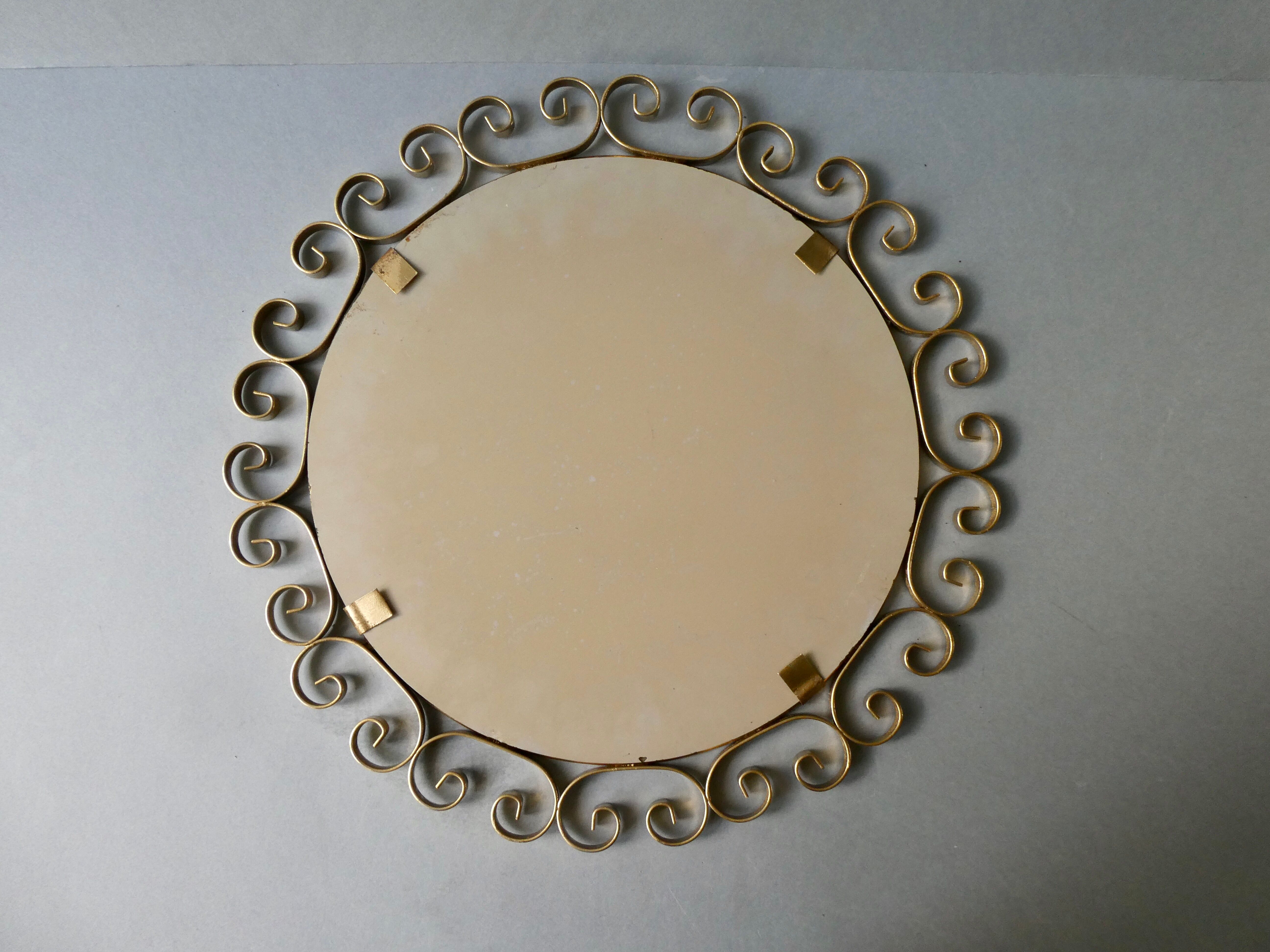 Round mirror with golden metal arabesques