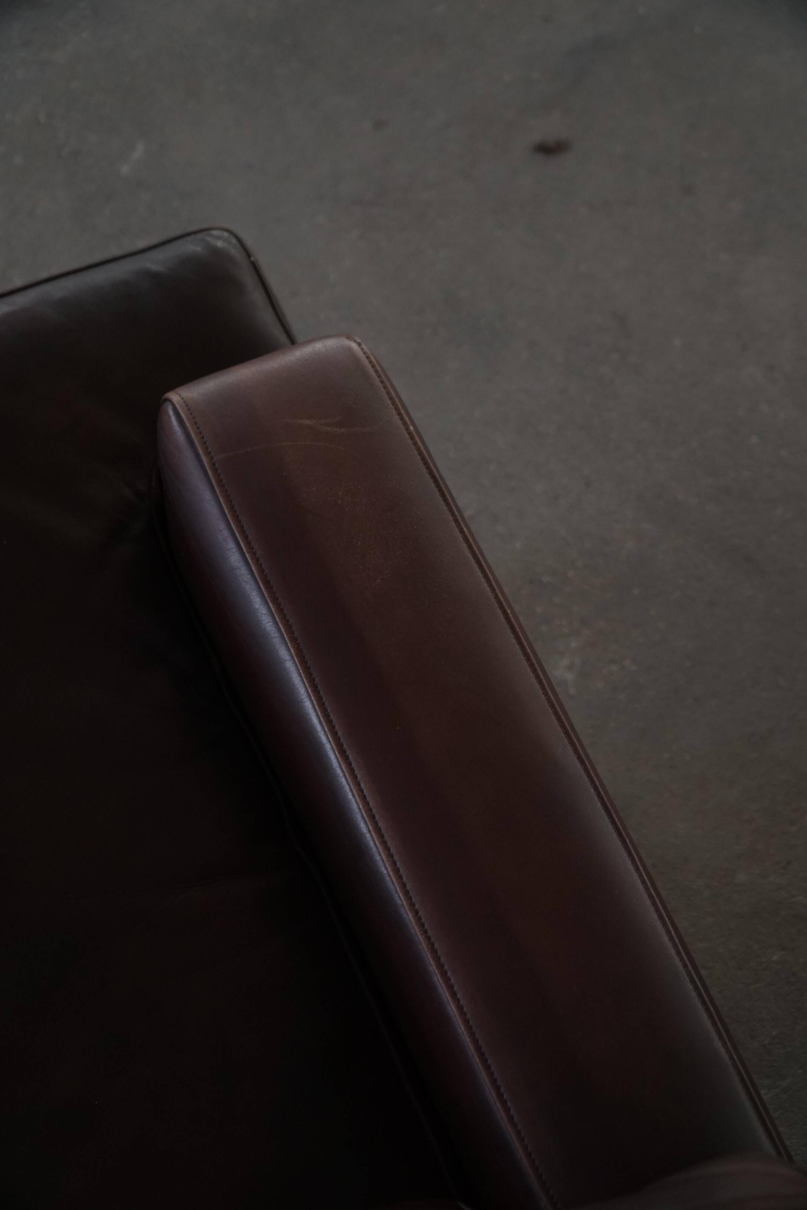 Pair of modern Danish lounge chairs in dark brown leather and rosewood, 1960s.