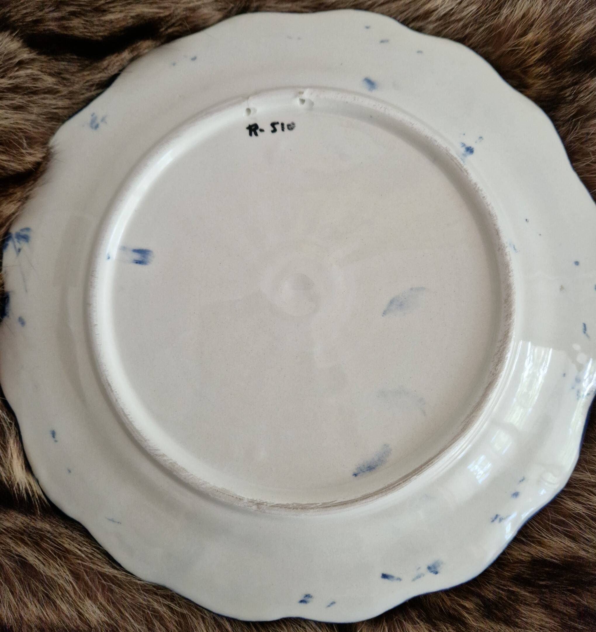Large hand-painted French faience plate with floral decoration in folk art style.