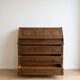 Antique wooden secretary with a drop-down front and drawers.