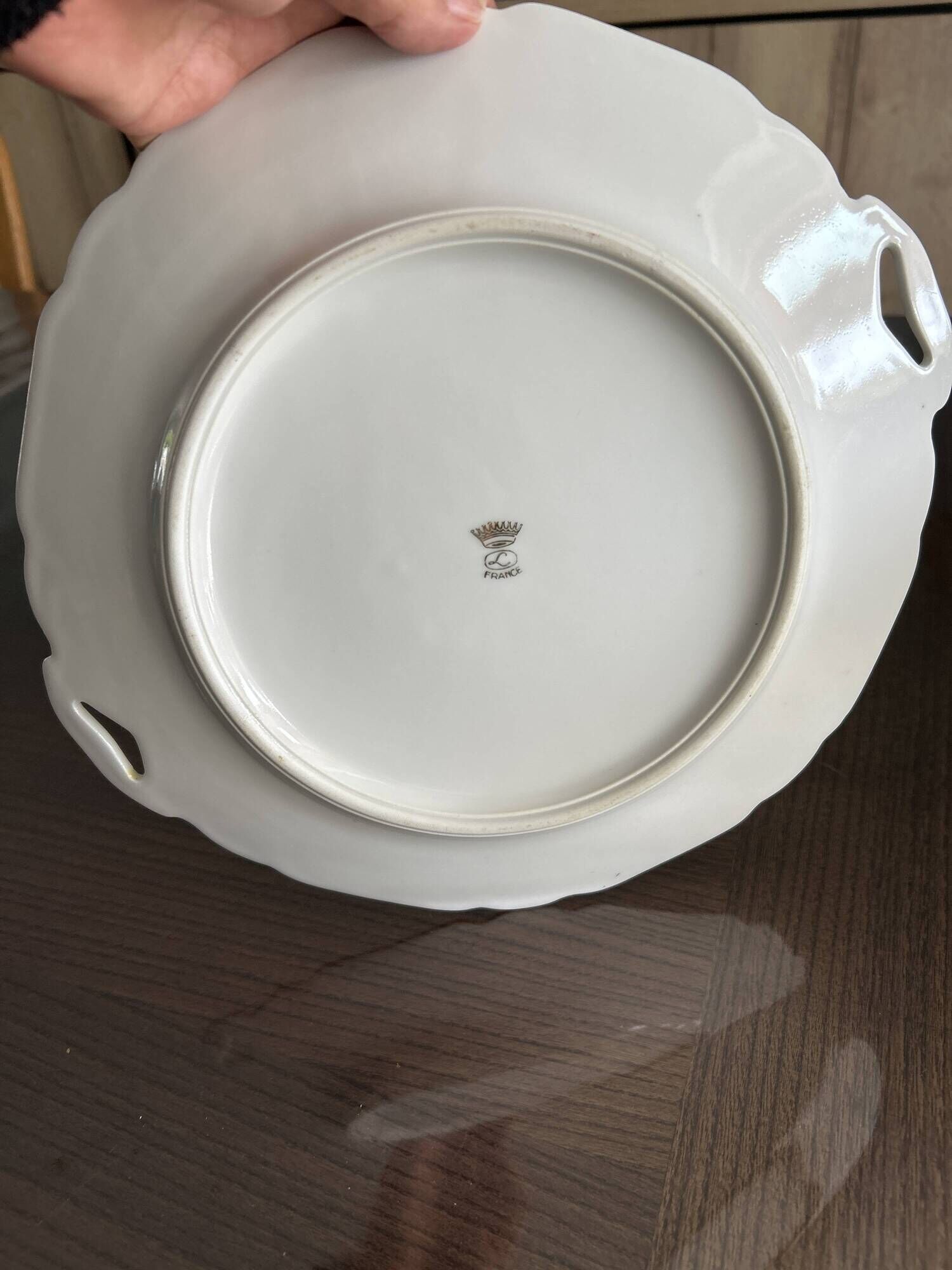 This dish seems to be a serving dish or a round plate with handles in porcelain.