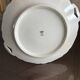 This dish seems to be a serving dish or a round plate with handles in porcelain.