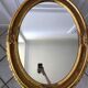 Grand miroir oval en stuc doré vintage