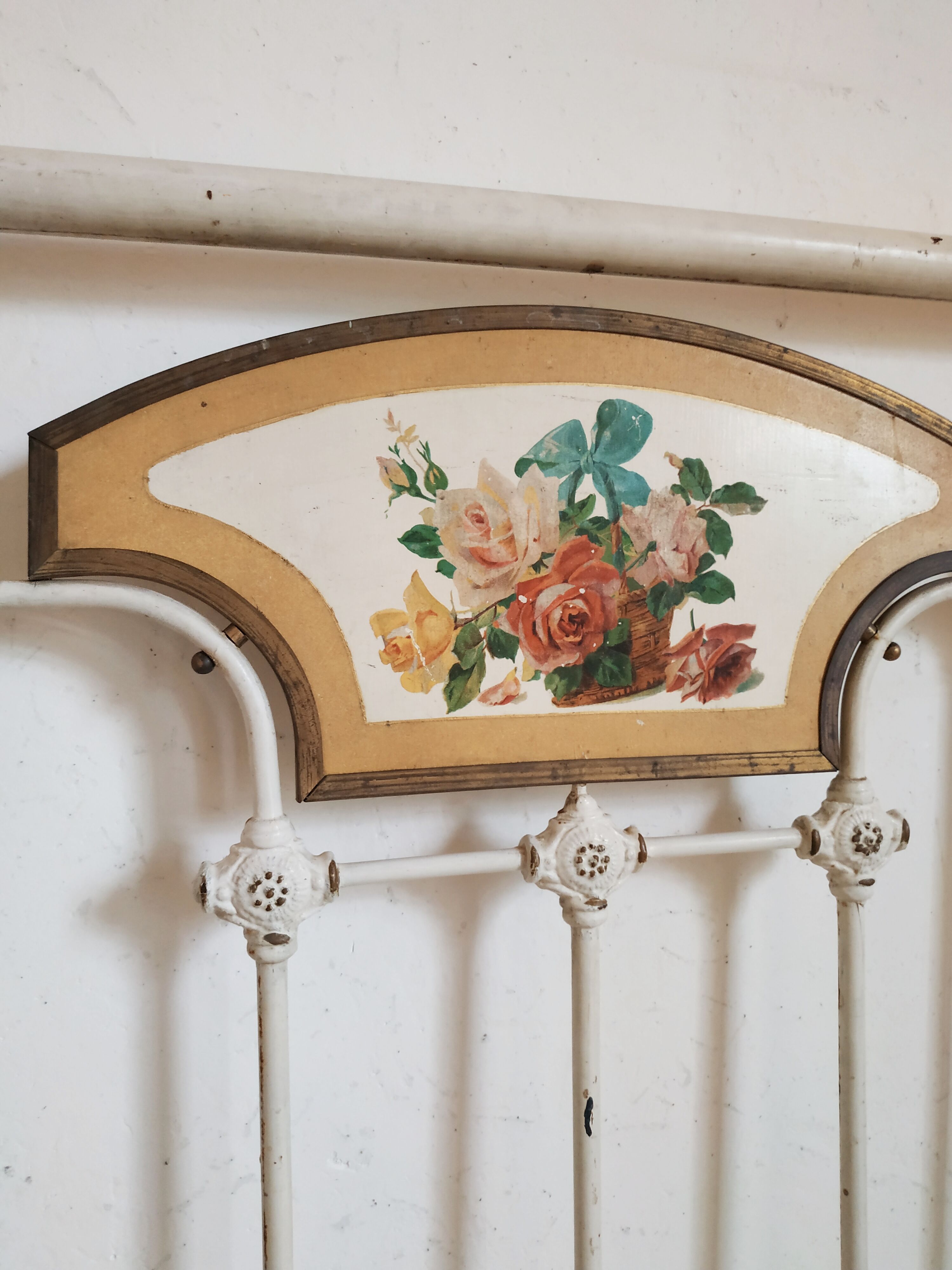 Cast-iron headboard and patinated white wood