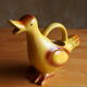 Ceramic watering can in white earthenware, yellow enamel and bird shape