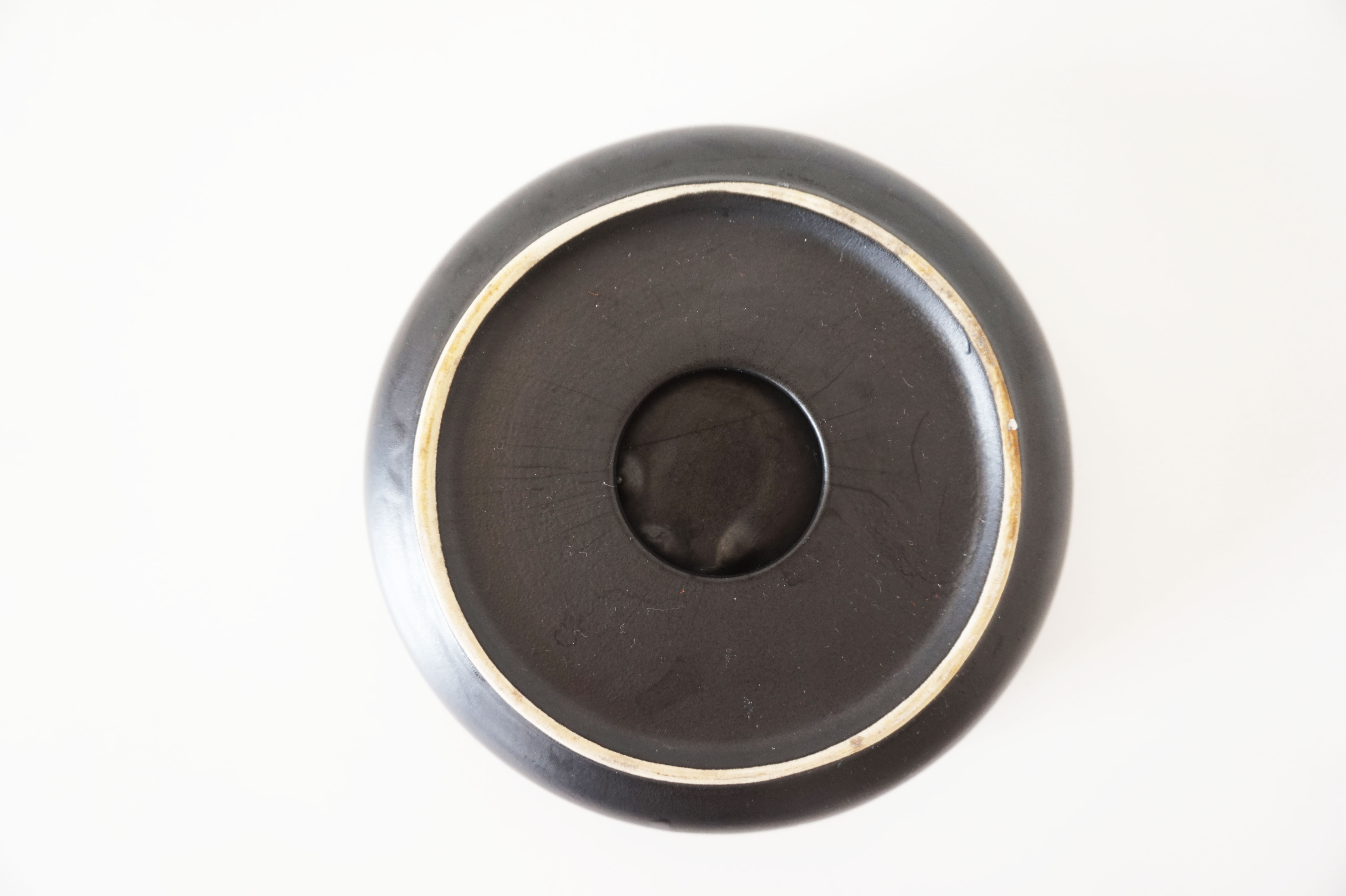 Empty round pocket in black ceramic