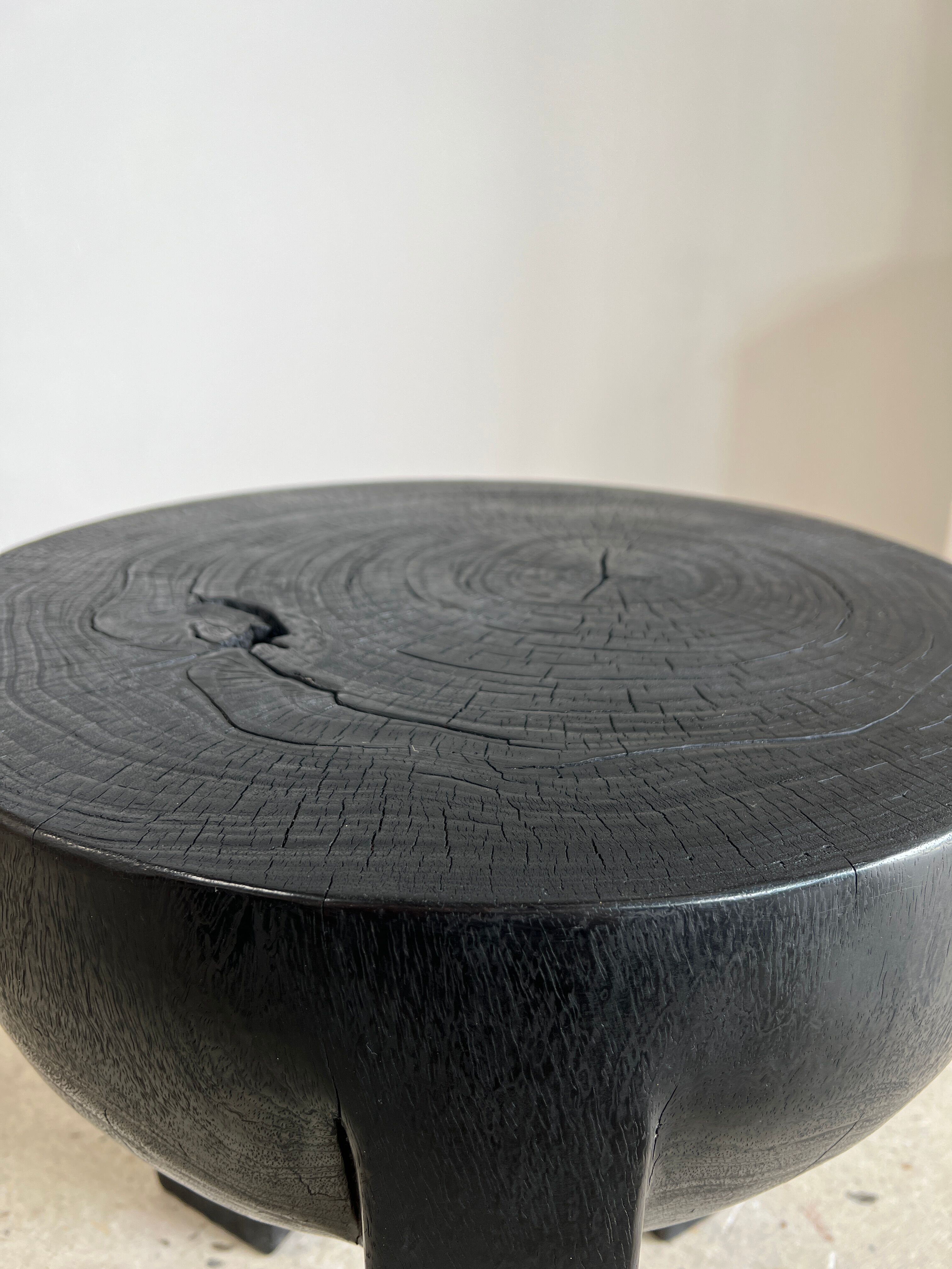 Black mango wood tripod side table with a semi-spherical top, height: 45 cm, diameter: 44 cm.