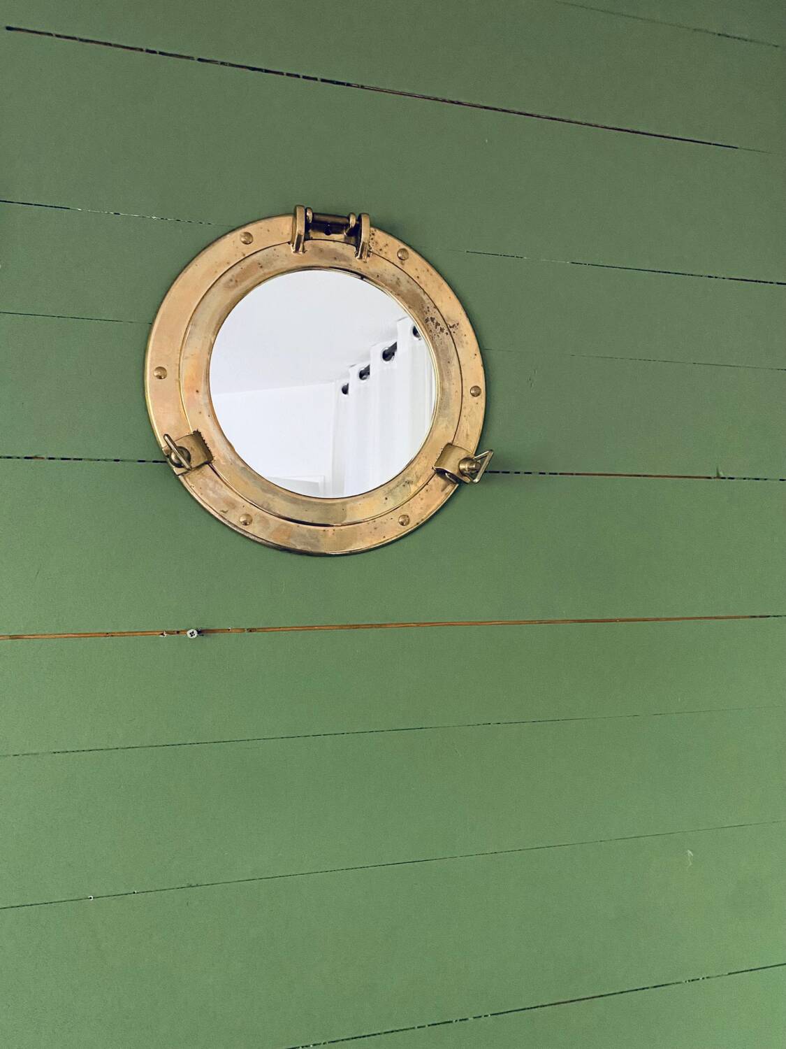 Porthole mirror in gilded brass