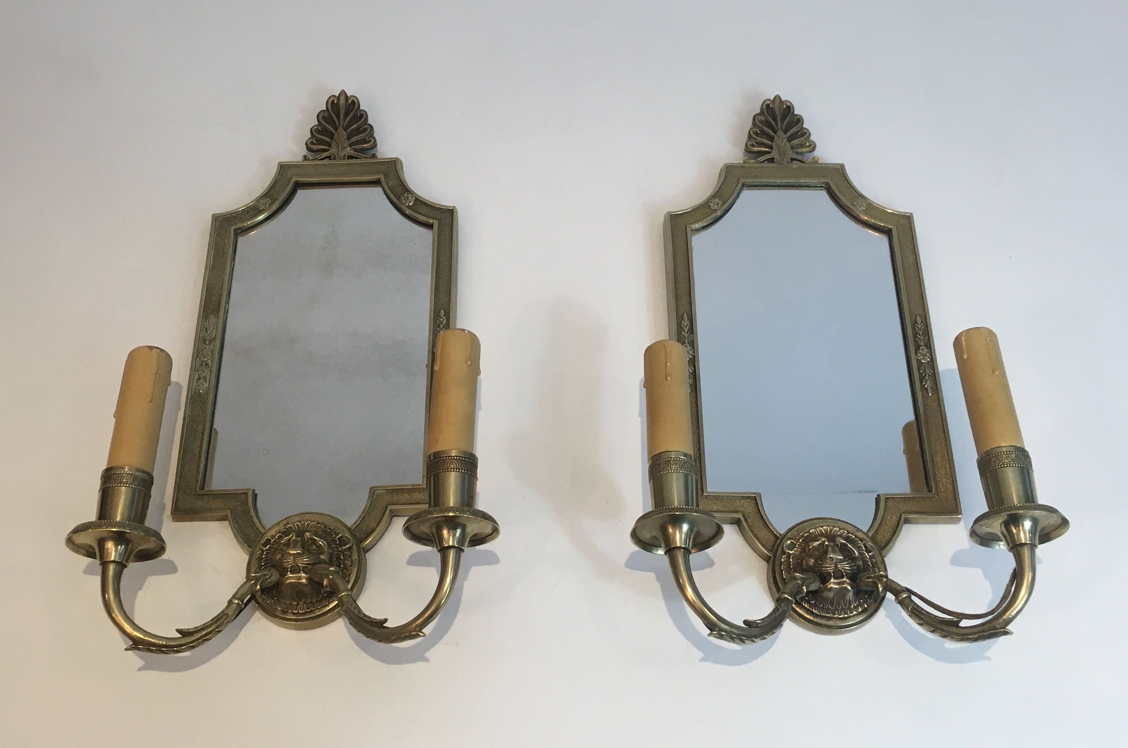 Pair of mirror and bronze wall lamps with lions' heads, french work. around 1940