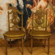Paire de chaises de musiciens en bois sculpté et doré de style Louis XVI
