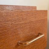 Vintage 1960s chest of drawers with covered handles.