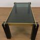Italian coffee table from the 70s, smoked glass, black and gold lacquered wood.