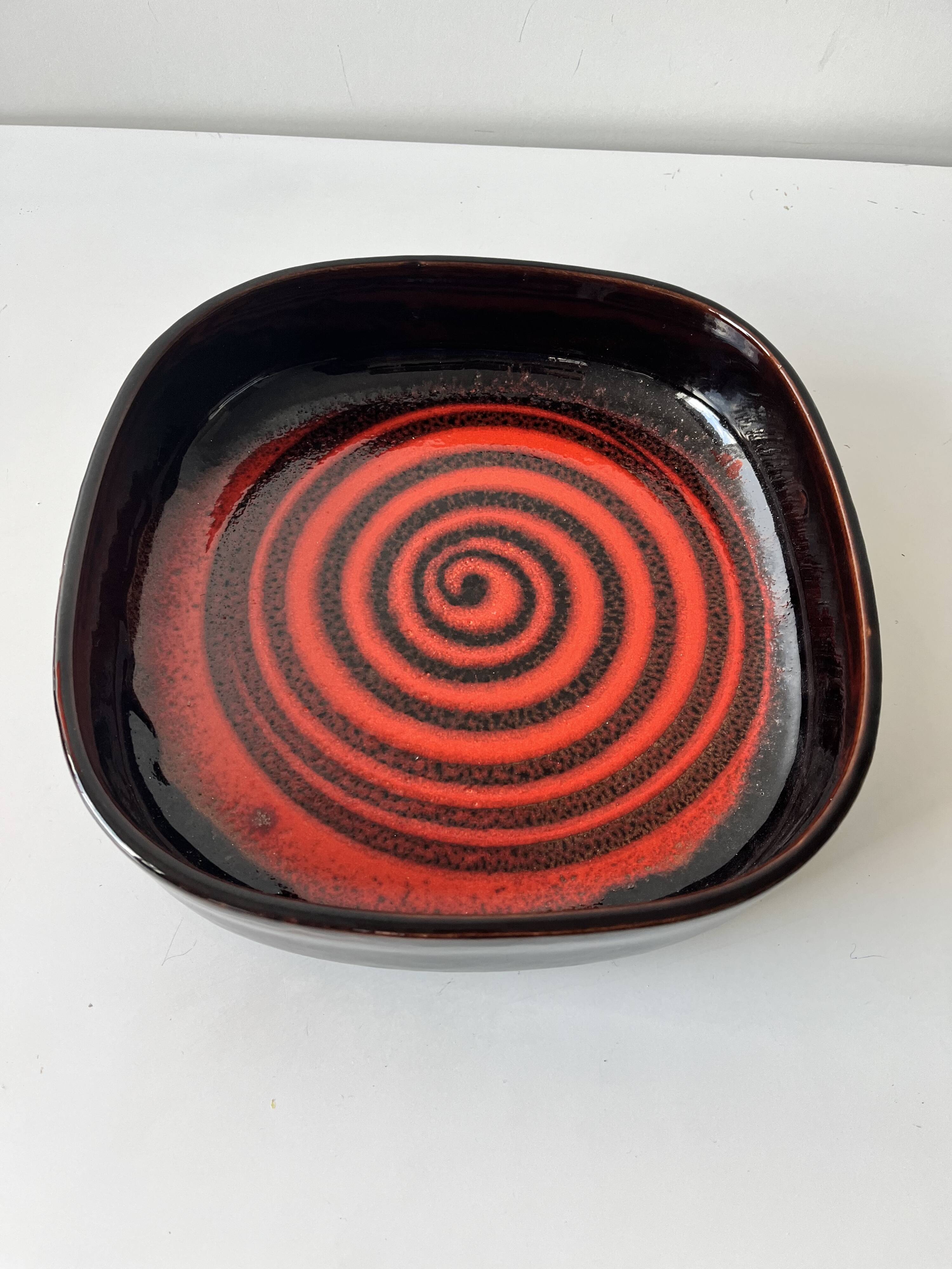 Large decorative ceramic catchall with red and black spiral pattern.