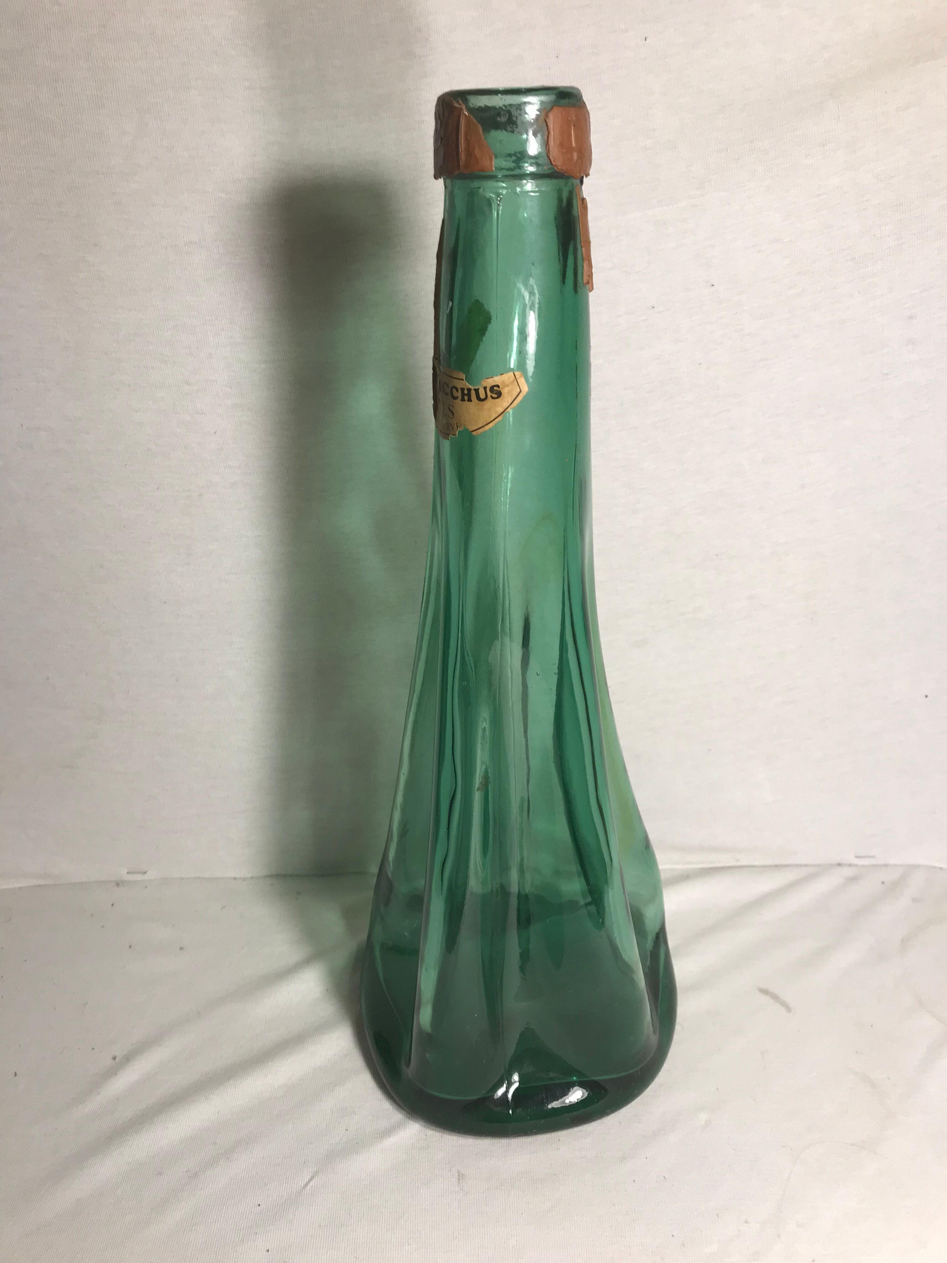 Old green molded glass bottle with rounded shape