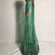 Old green molded glass bottle with rounded shape