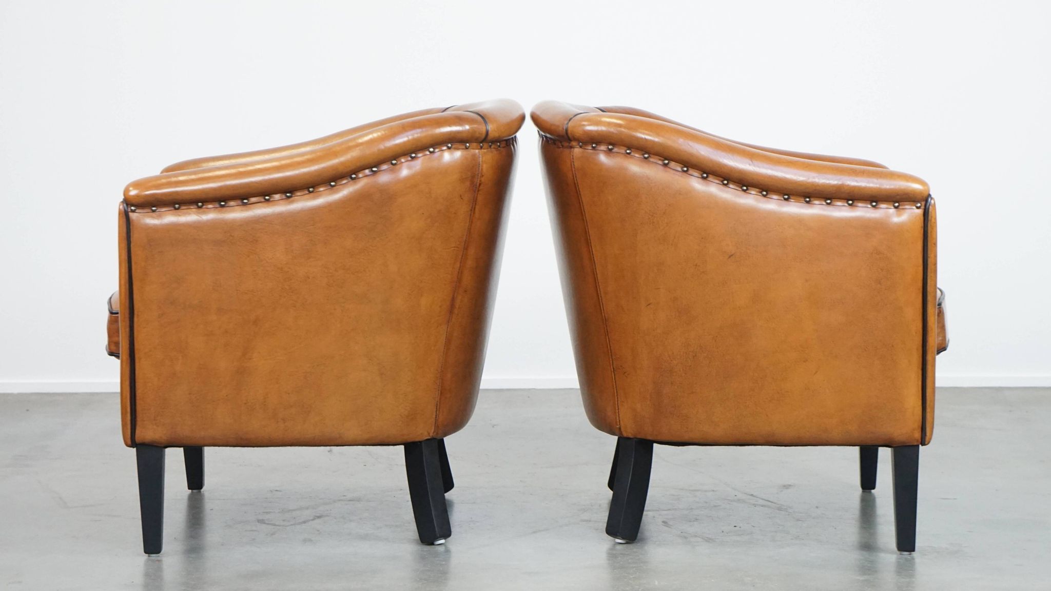 Set of 2 sheep leather club chairs finished with black piping
