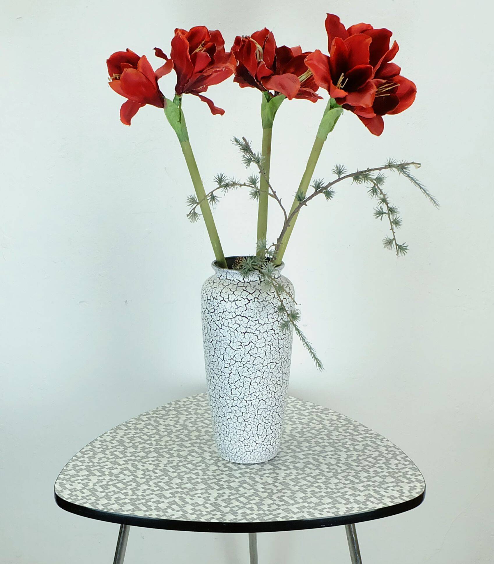 Table basse des années 1950 à trois pieds avec un plateau en formica et des pieds en chrome inclinés.