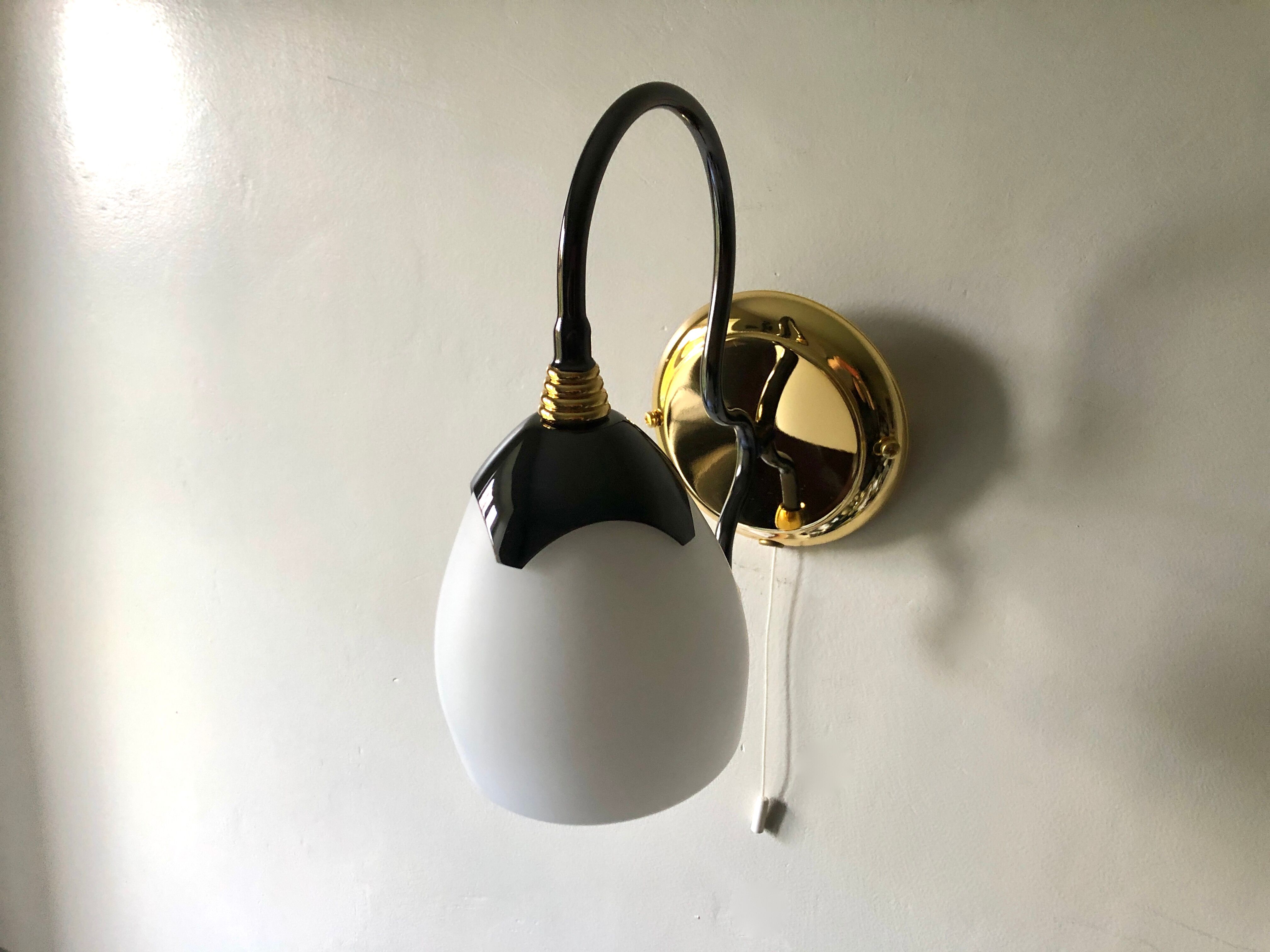 Black and gold wall light with white opaline flower, Italy 1990.