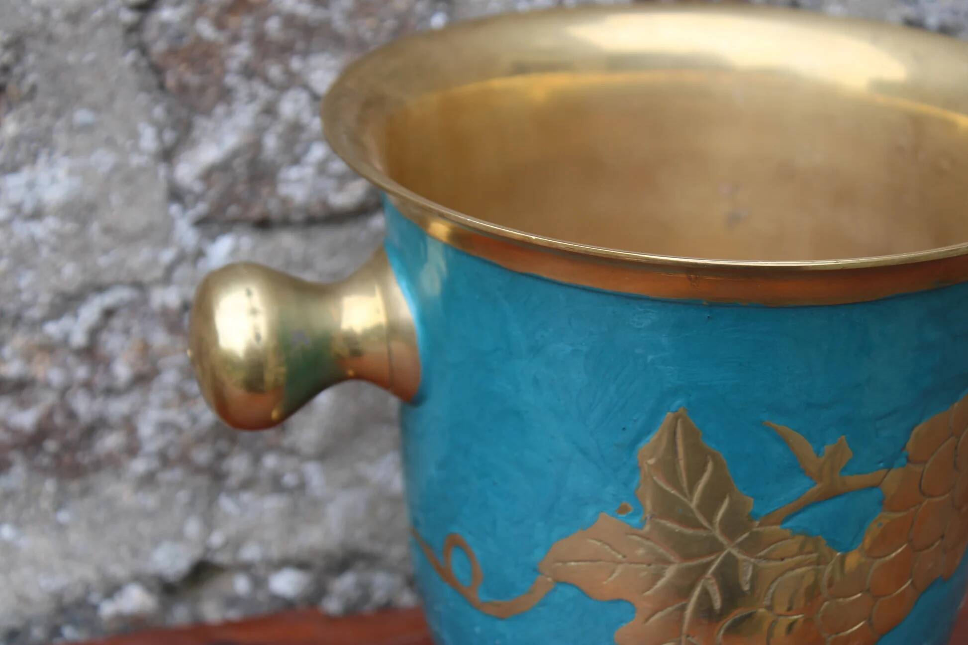Vintage turquoise brass champagne bucket with grape decoration.