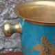 Vintage turquoise brass champagne bucket with grape decoration.