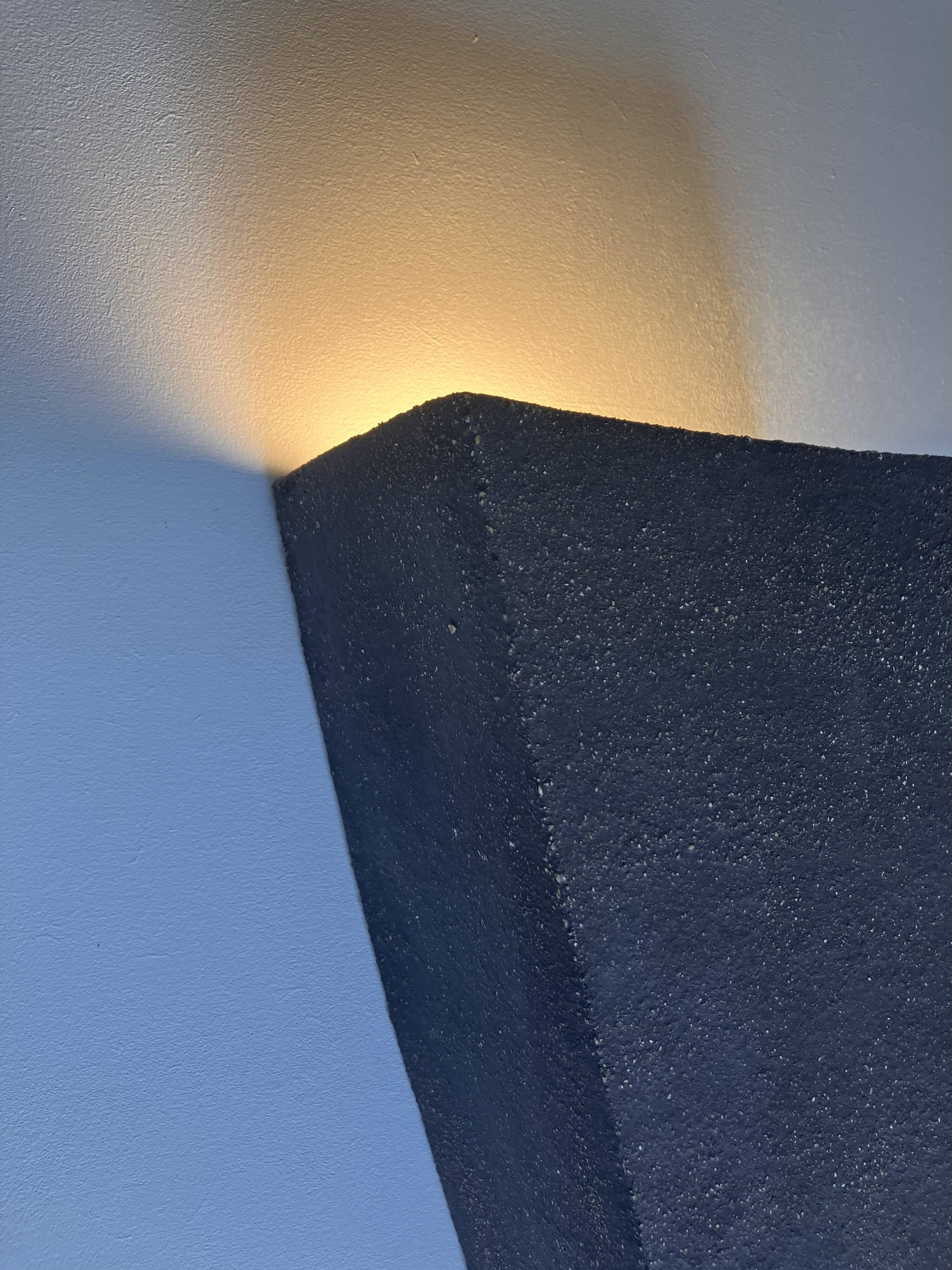 Graphical black stoneware ceramic wall light with handmade ring.