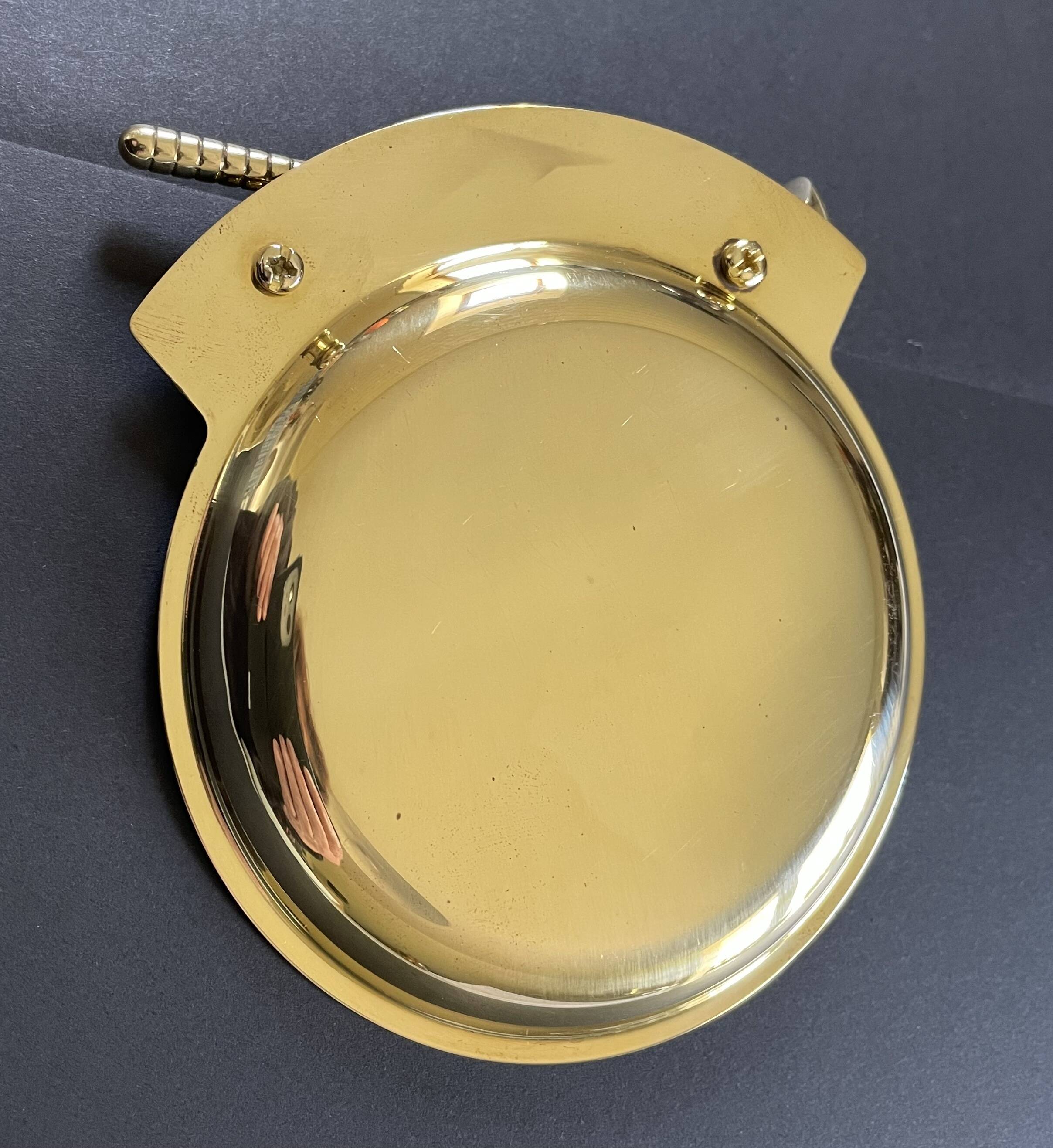 Round brass pocket tray with club and golf ball decoration.
