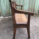 Duo of old solid oak benches with backs and armrests.