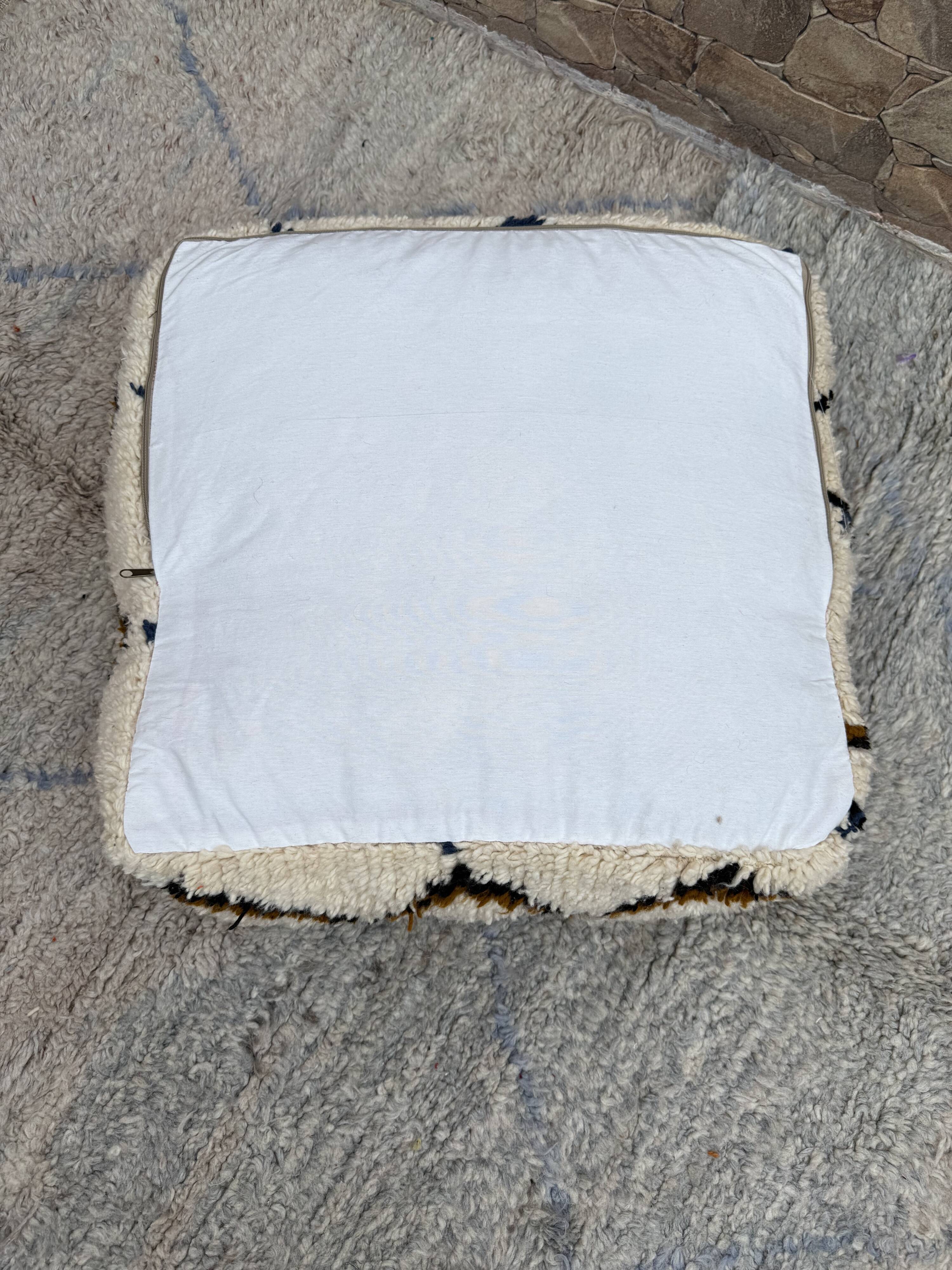 Berber floor pouf: Handwoven Moroccan wool cushion.