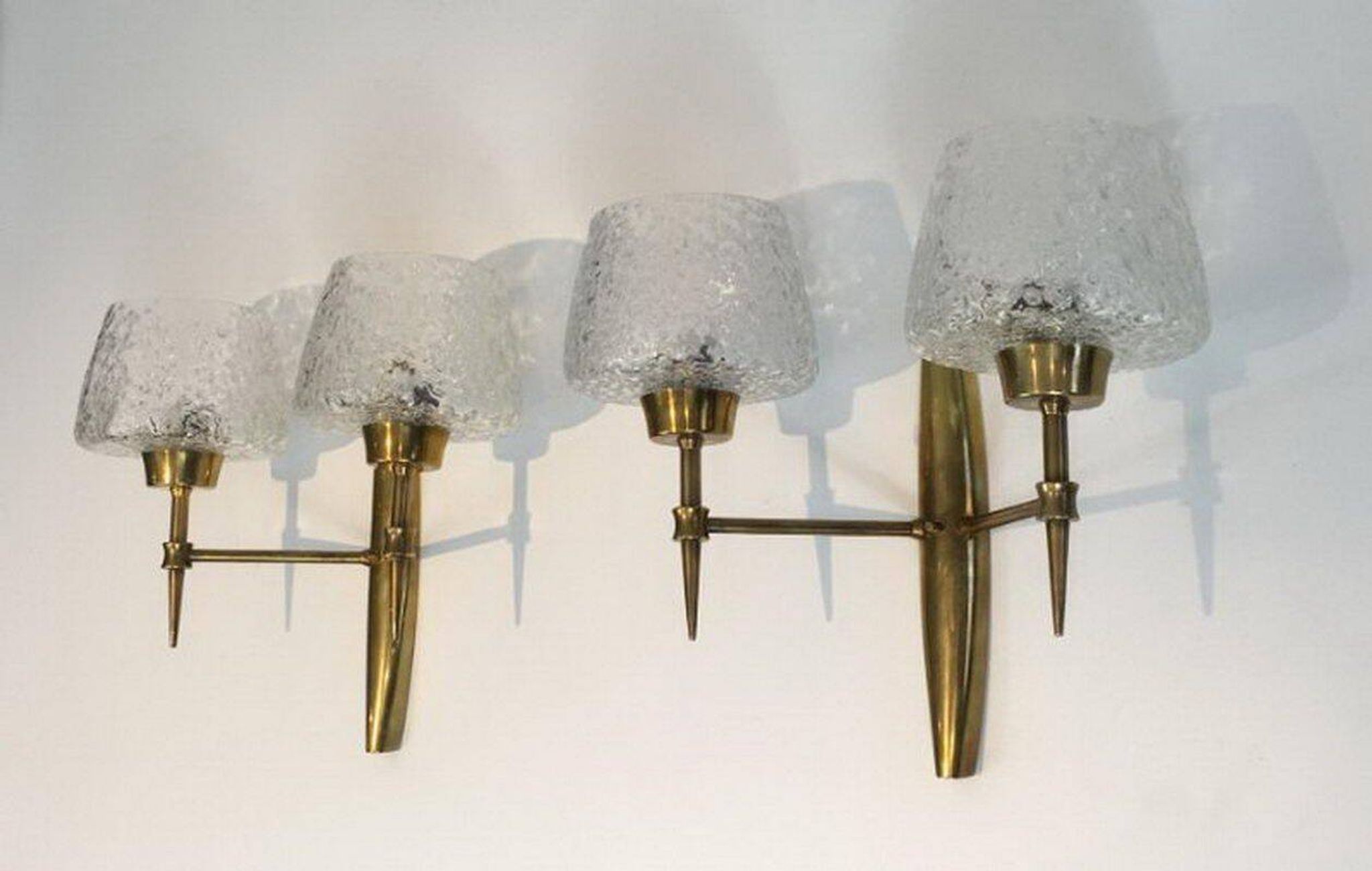 Pair of bronze wall sconces with worked glass reflectors. Stilnovo