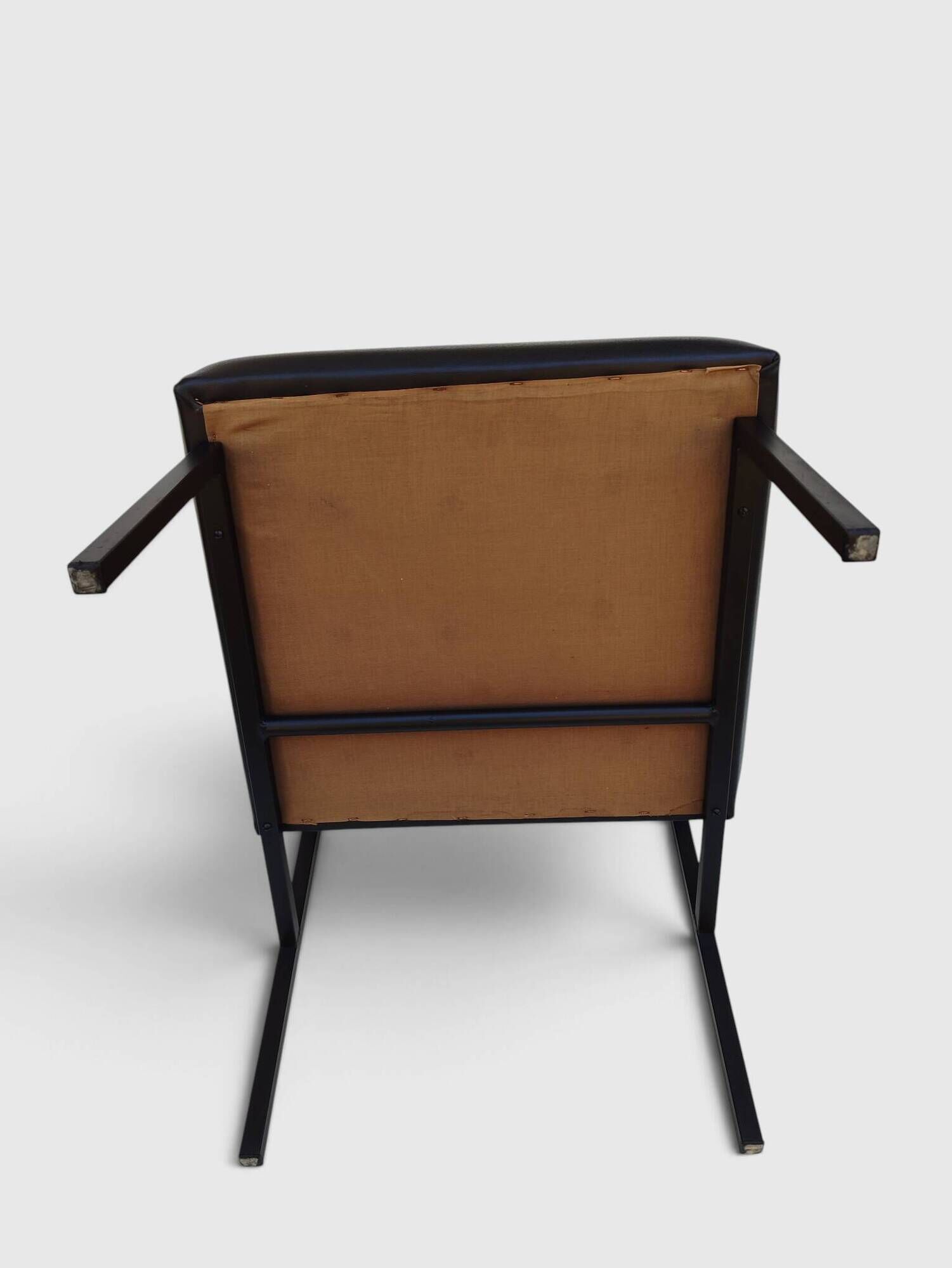 Modernist armchair in black faux leather and metal – 1960s