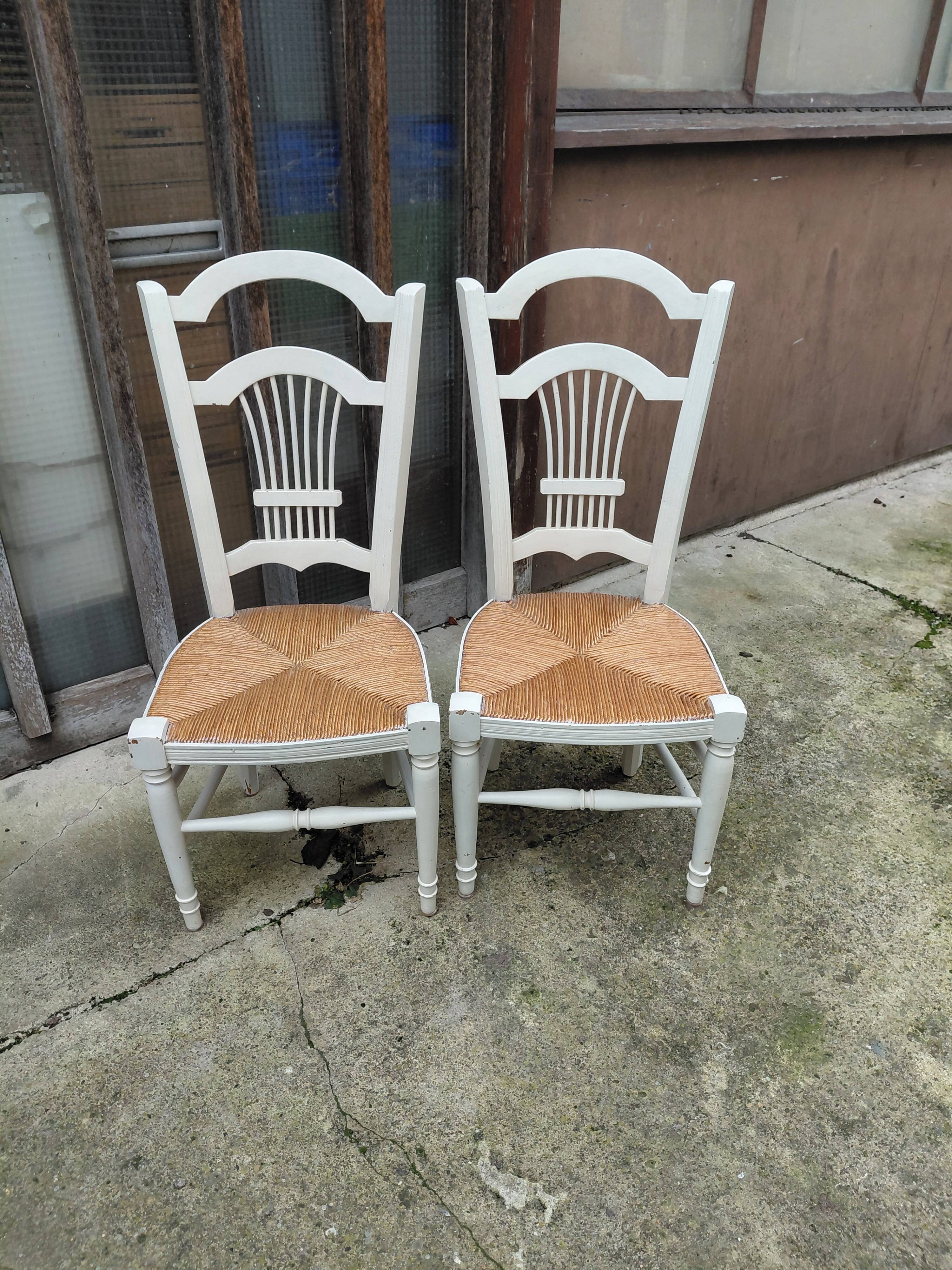 Pair of straw-seated chairs with white-stained wood.