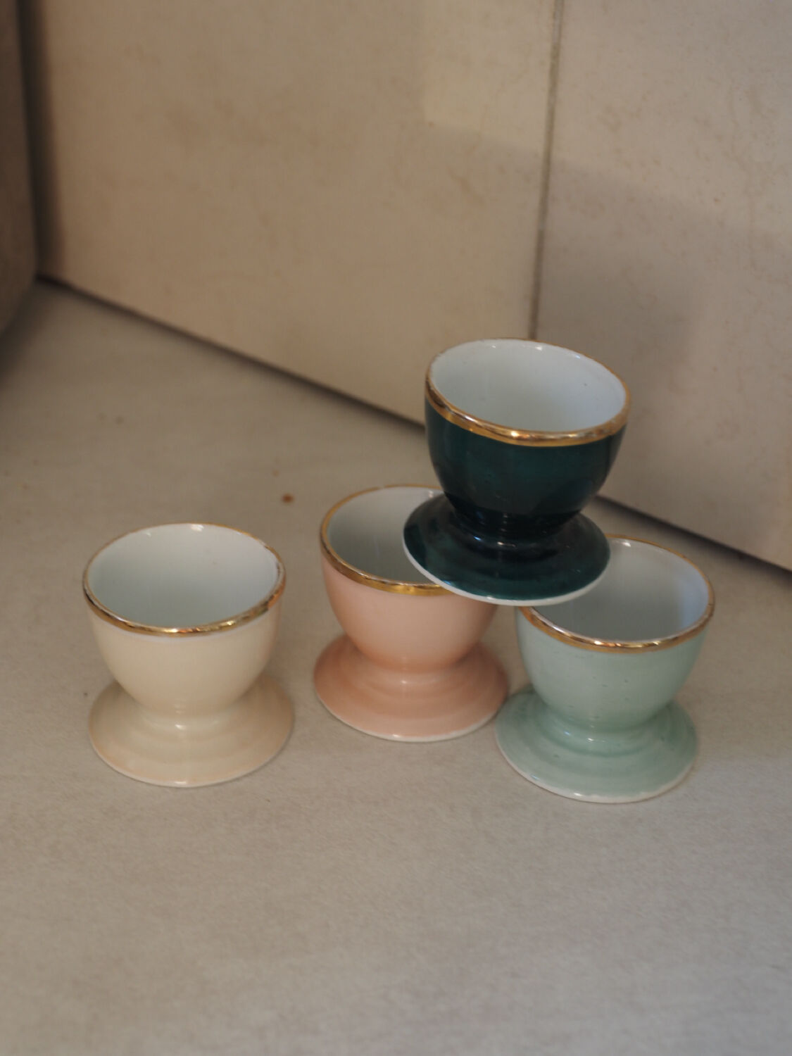 Four coloured egg cups with a golden rim from the 50s.
