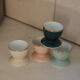 Four coloured egg cups with a golden rim from the 50s.
