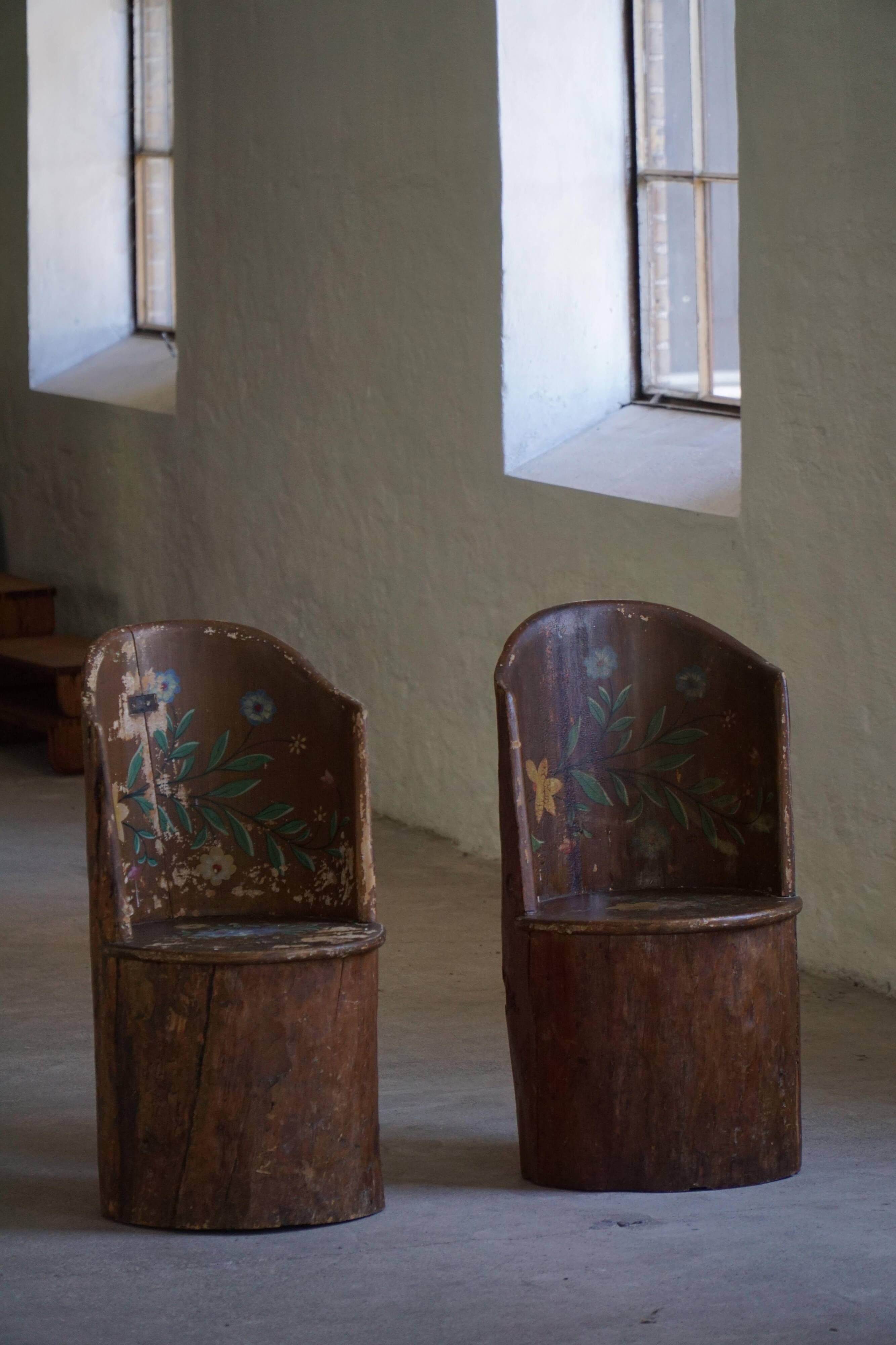 Pair of Swedish folk art stump chairs, decorated with painted floral motifs, late 19th century.