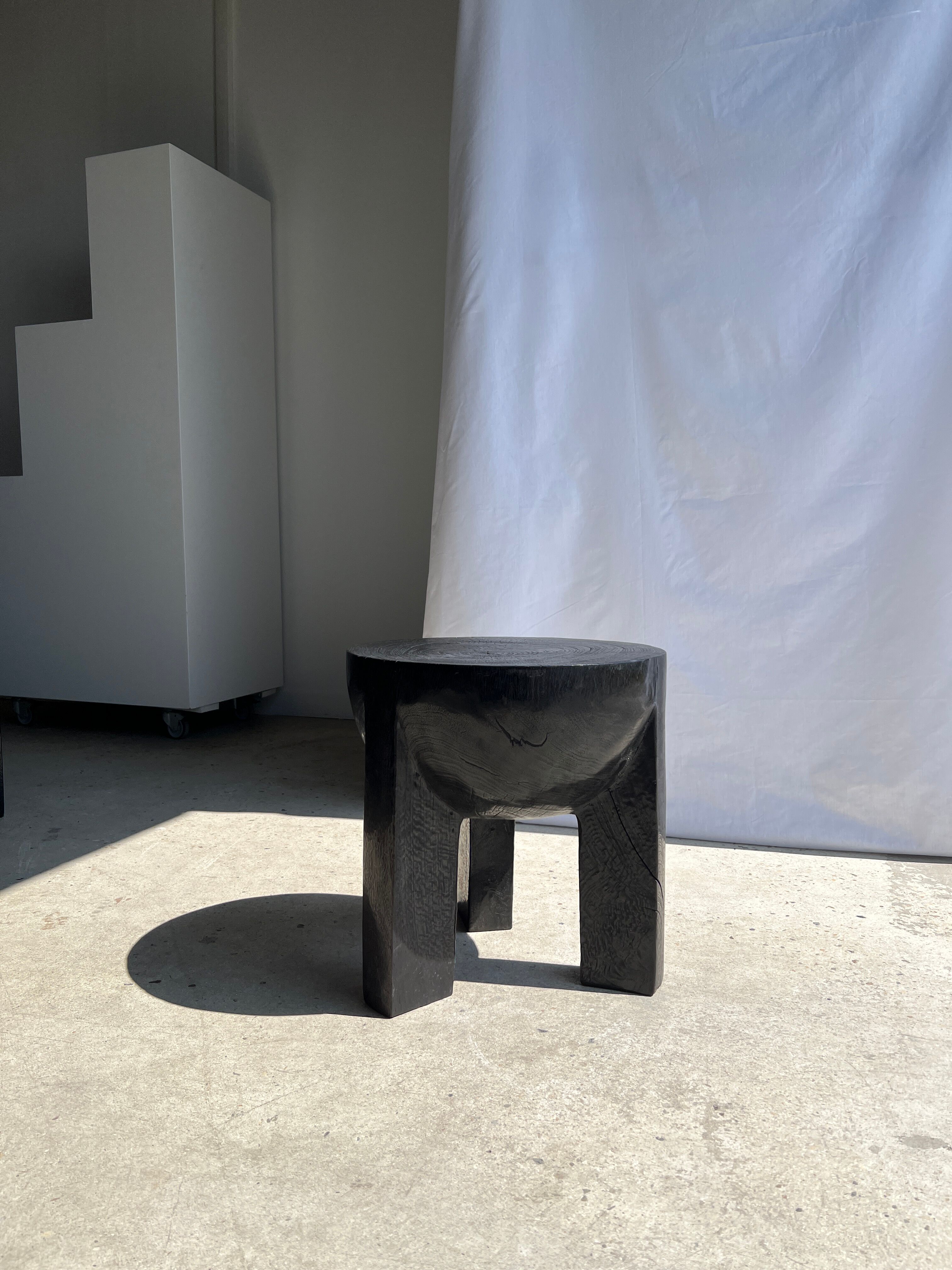 Black mango wood tripod side table with a semi-spherical top, height: 45 cm, diameter: 44 cm.