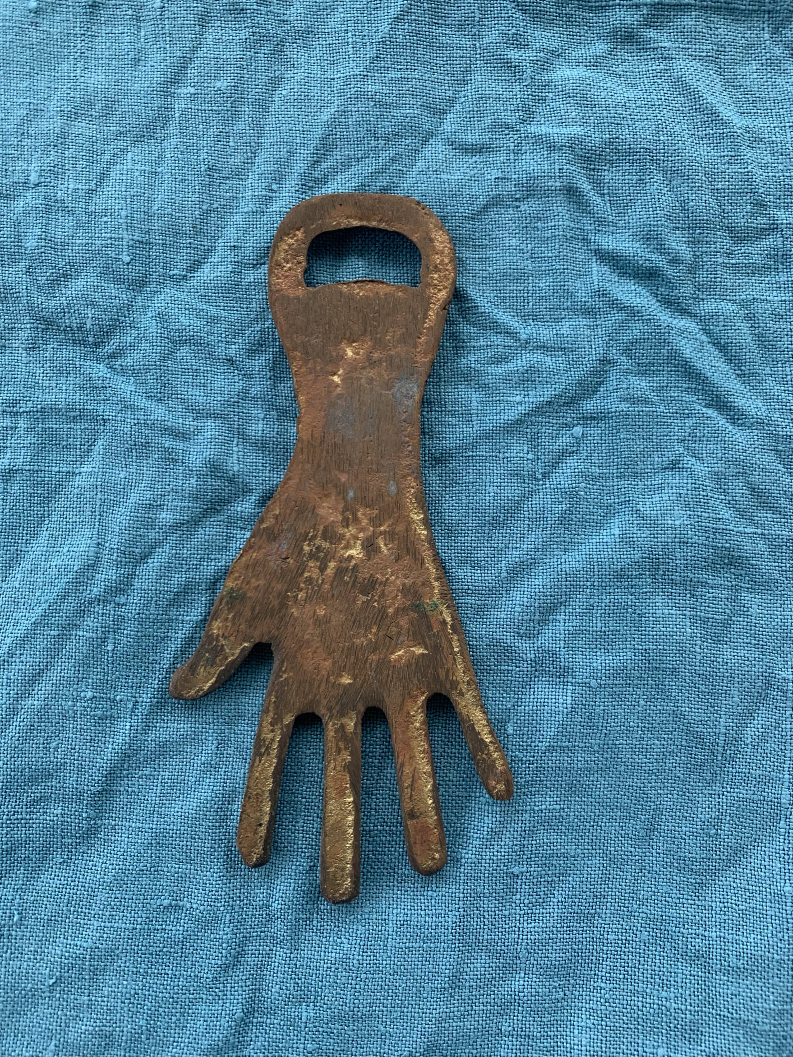 Two brass bottle openers in the shape of a chiseled hand vintage oriental décor