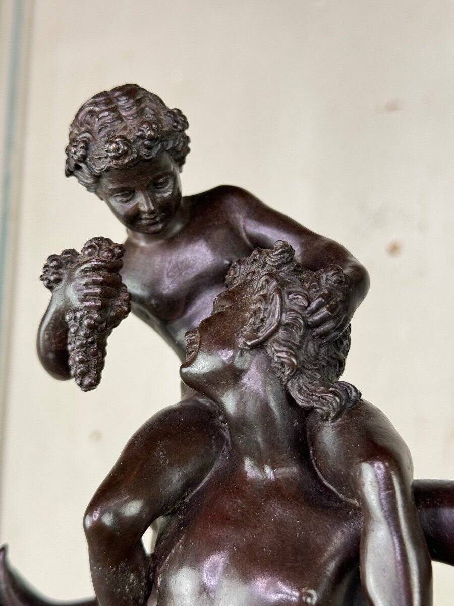 Dionysus on the shoulders of a satyr, bronze after the antique on a yellow Siena base.