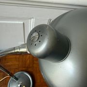 Industrial metal workshop lamp with a gooseneck.