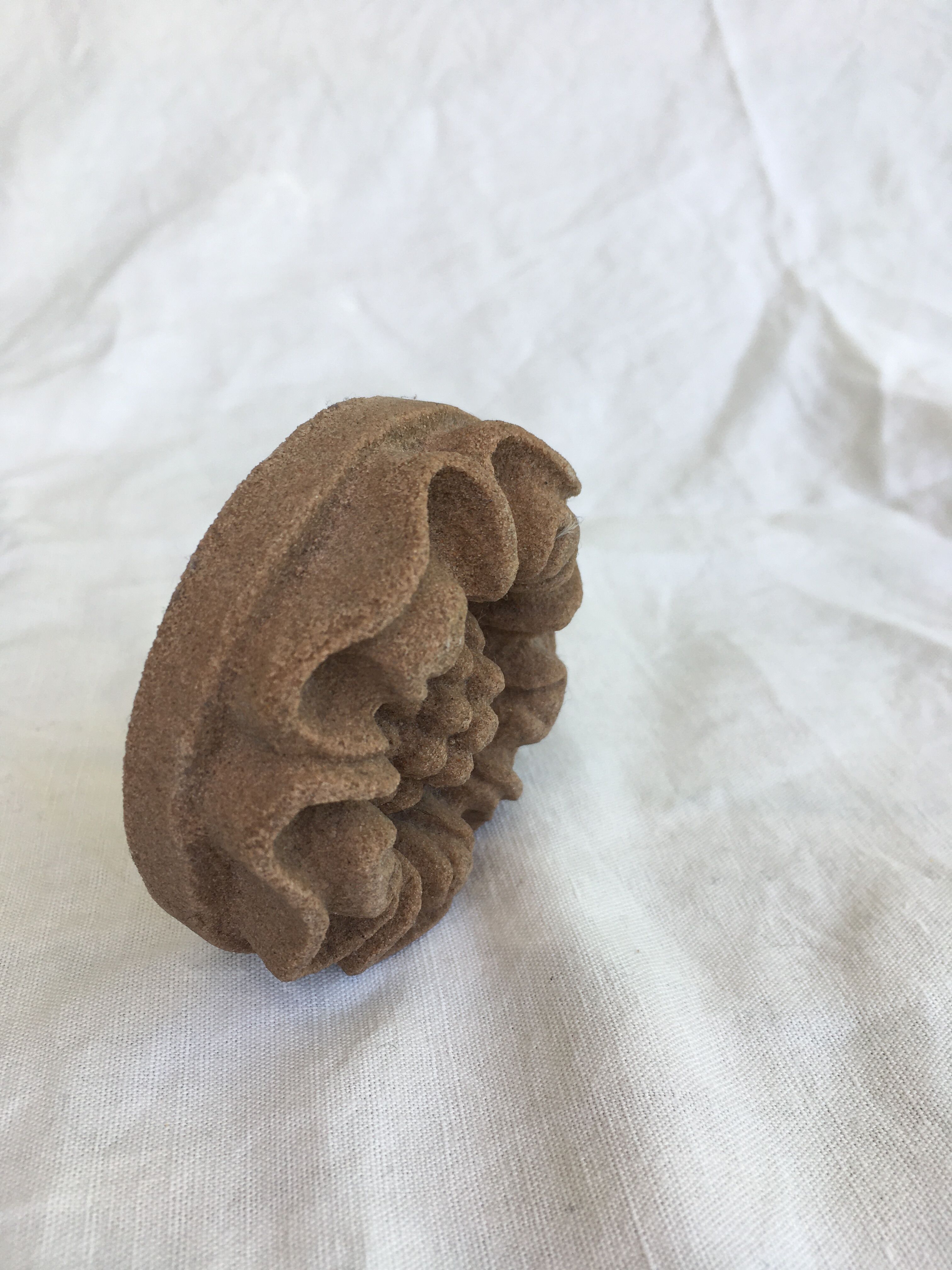 Pink sandstone paperweight in the shape of a rosette