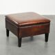 Large dark brown square ottoman made of sheepskin with black piping