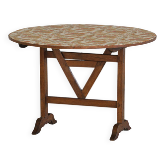 19th-century French round wine table with an adjustable top and floral textile surface.