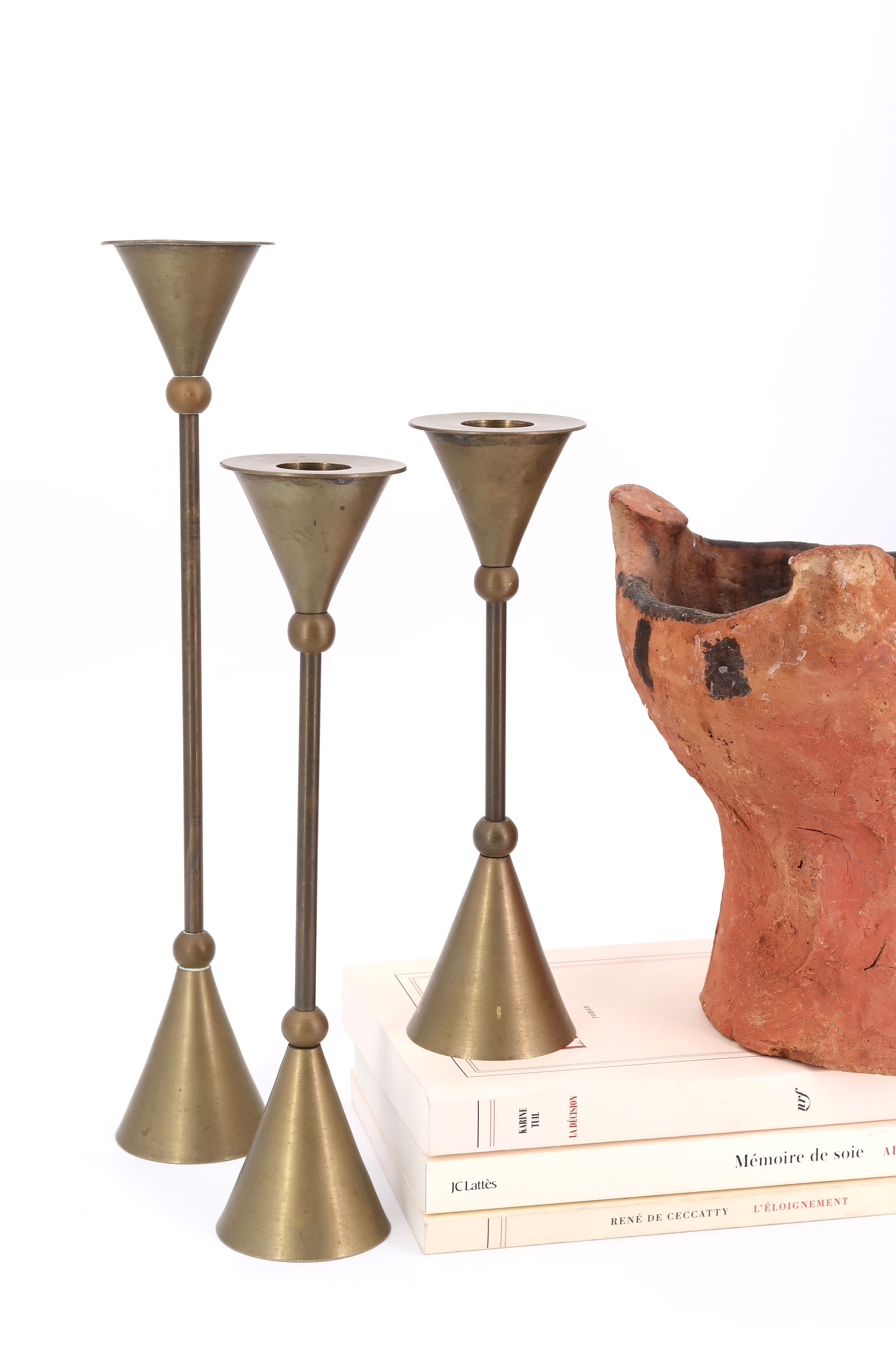 Trio of brass candlesticks by Christian de Beaumont