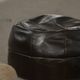 Vintage black leather pouf/ottoman with a rounded shape, French mid 20th Century.