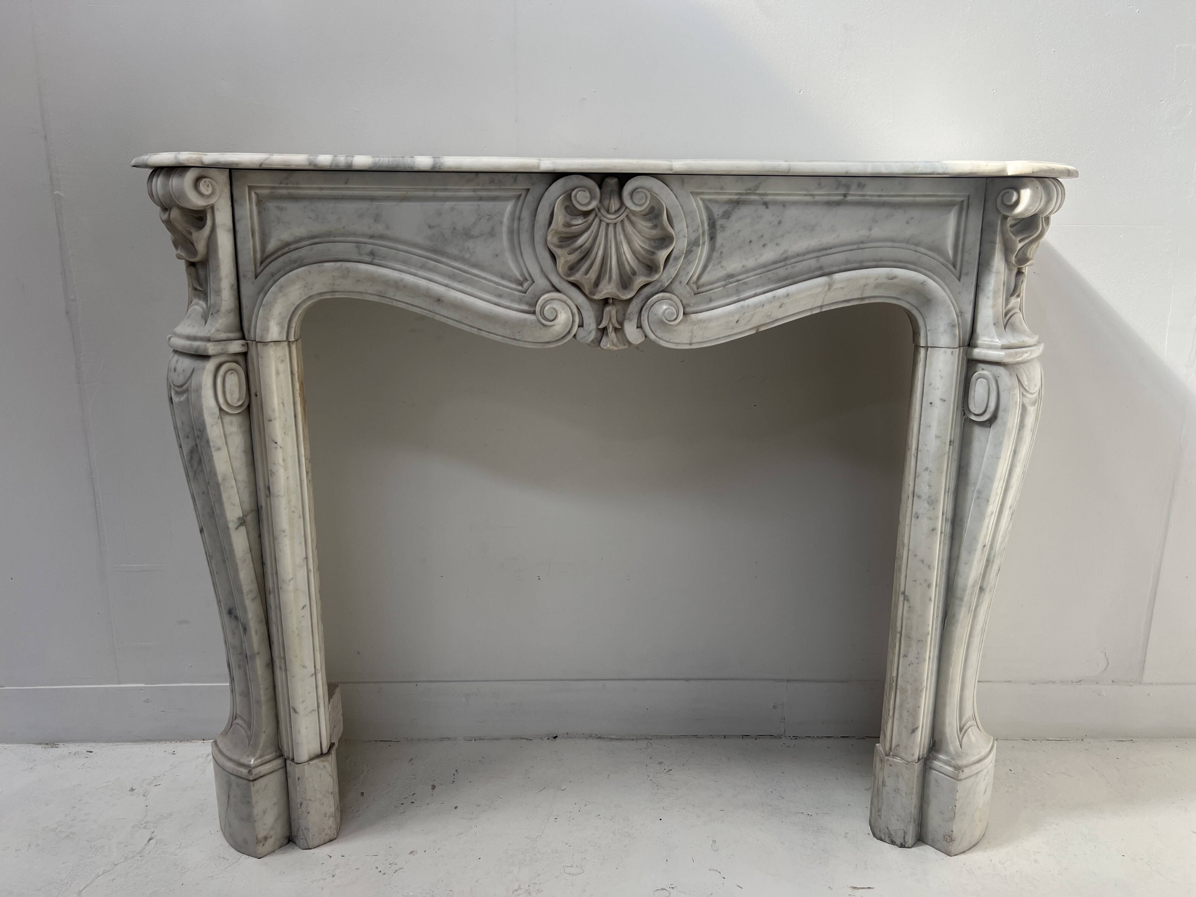 Louis XV style fireplace in veined white Carrara marble, 19th century.