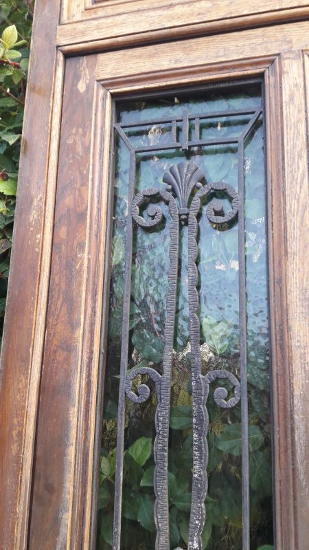 Oak entrance door and its frame and transom, wrought iron gates