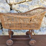 Old rattan cradle on wheels