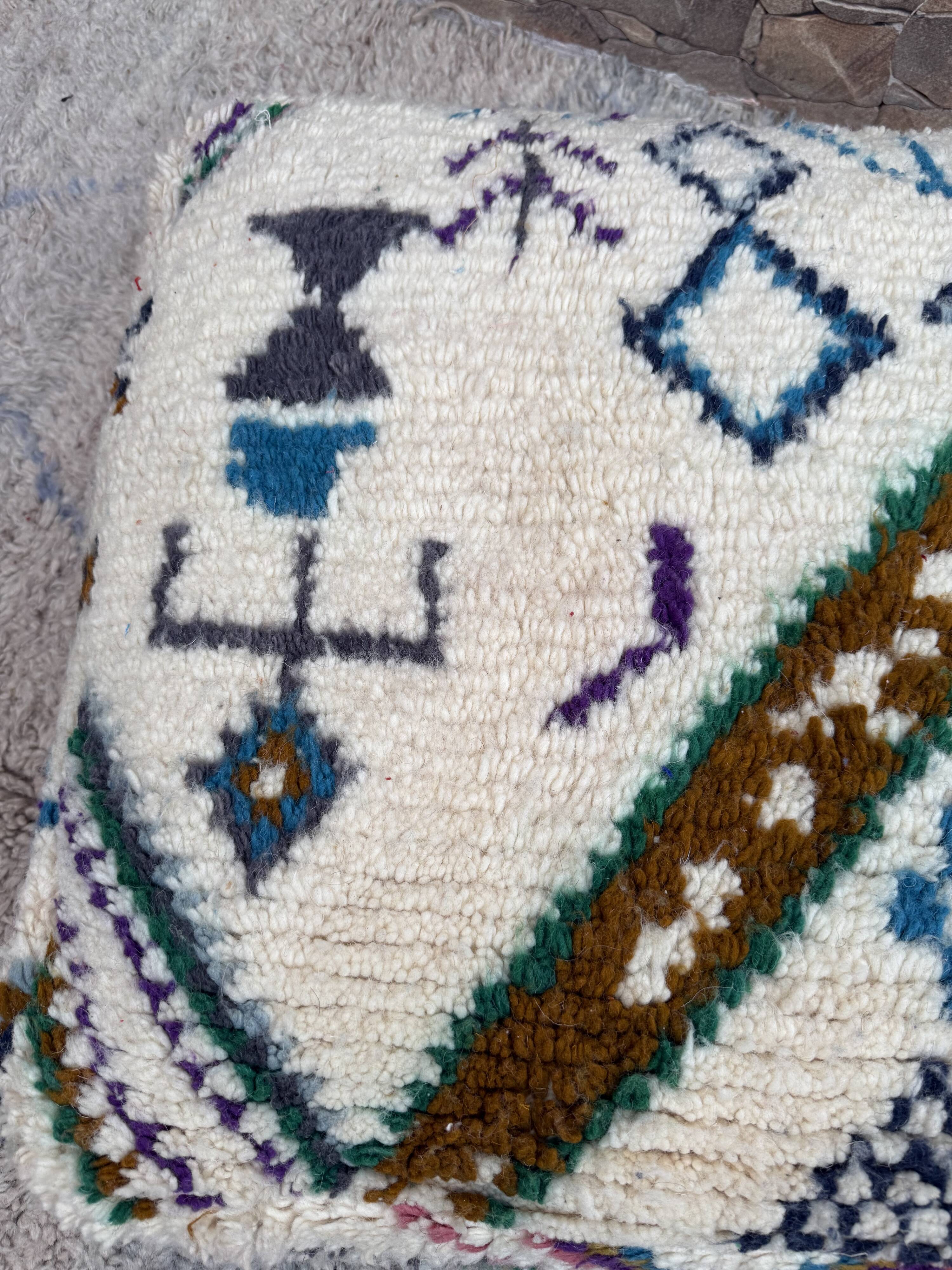 Berber floor pouf: Handwoven Moroccan wool cushion.